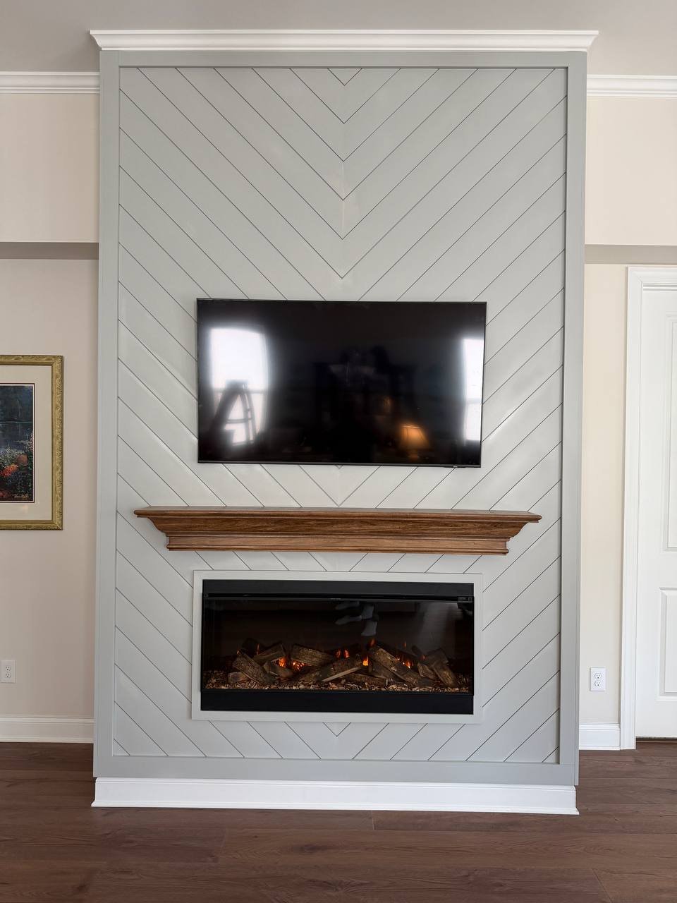 Herringbone fireplace wall with electric fireplace and wood mantel, Charlotte NC