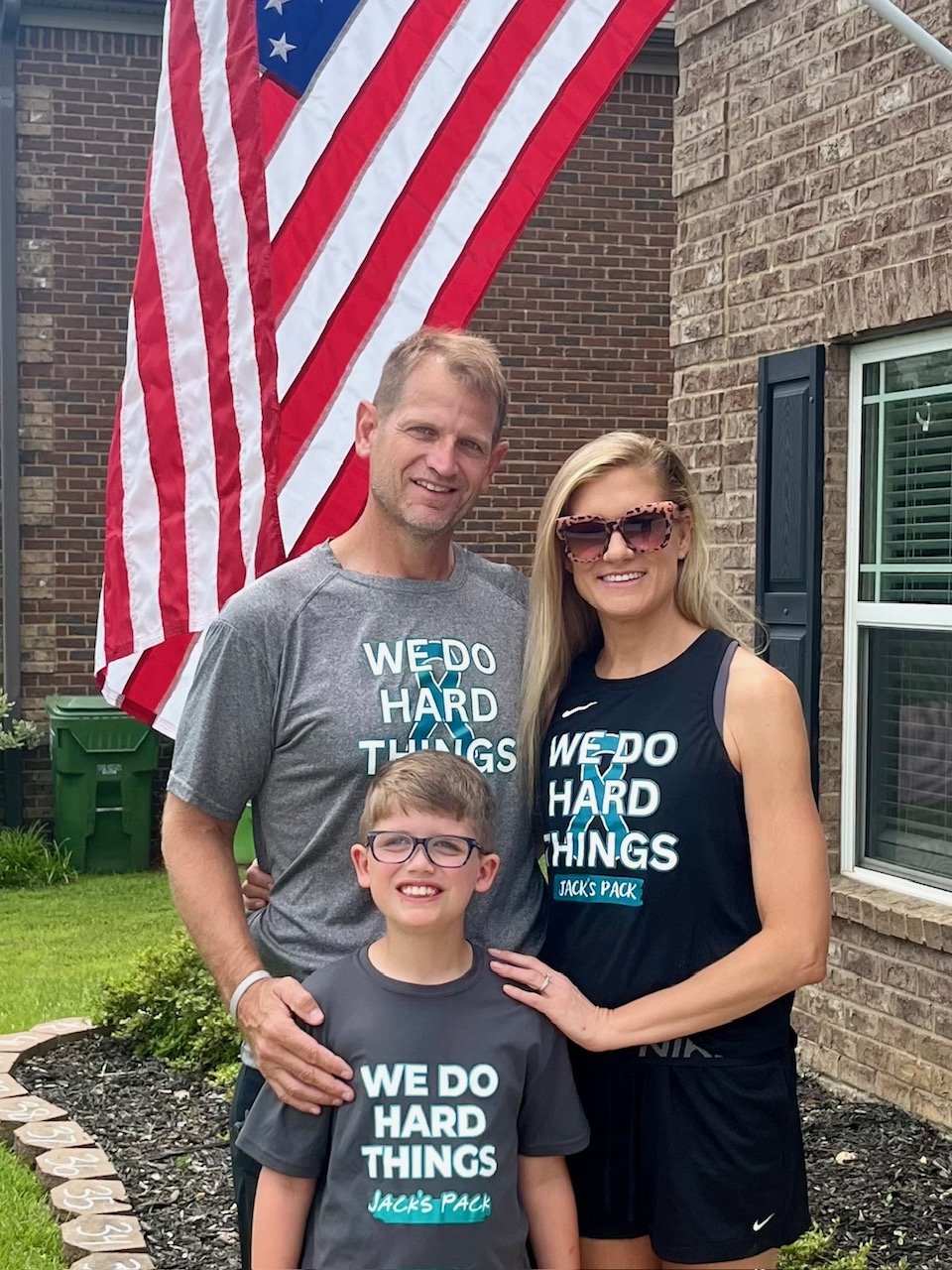 Jack and his family standing in front of their home