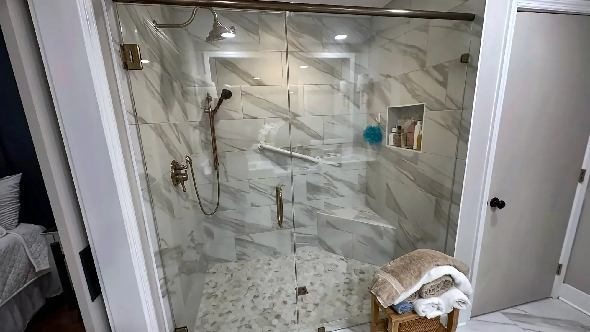 Walk-in glass shower with marble-look tile in an Auburn, AL bathroom remodel