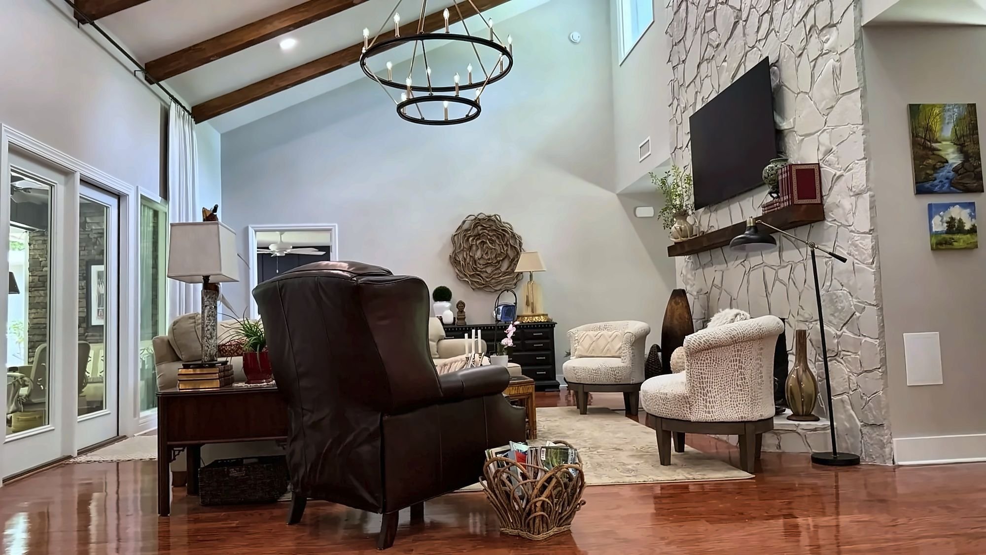 Great room with vaulted ceiling and stone fireplace in an Auburn, AL whole-home remodel