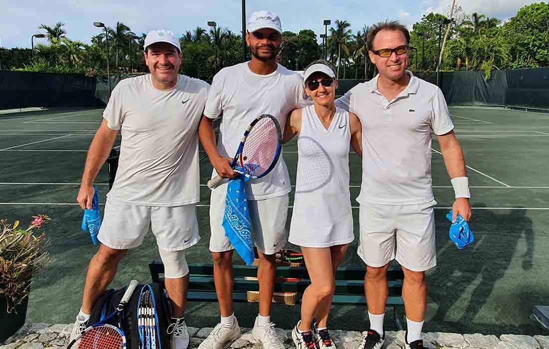 Parent posing in tennis whites on the court.