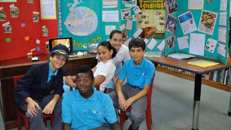 Photo of group of five students oi classroom smiling for the camera.