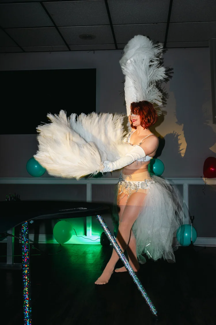 Talia Hazard performing with white feather fans and a feathered headdress