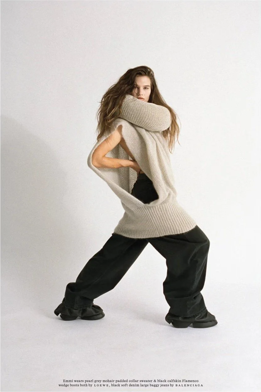 Model in an oversized knit vest and wide black trousers