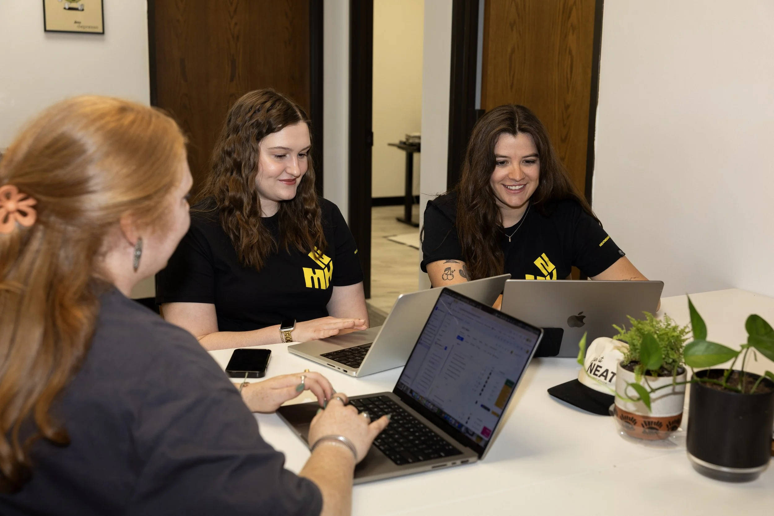 The Neat Media House social media team sitting around a desk working on client strategy.