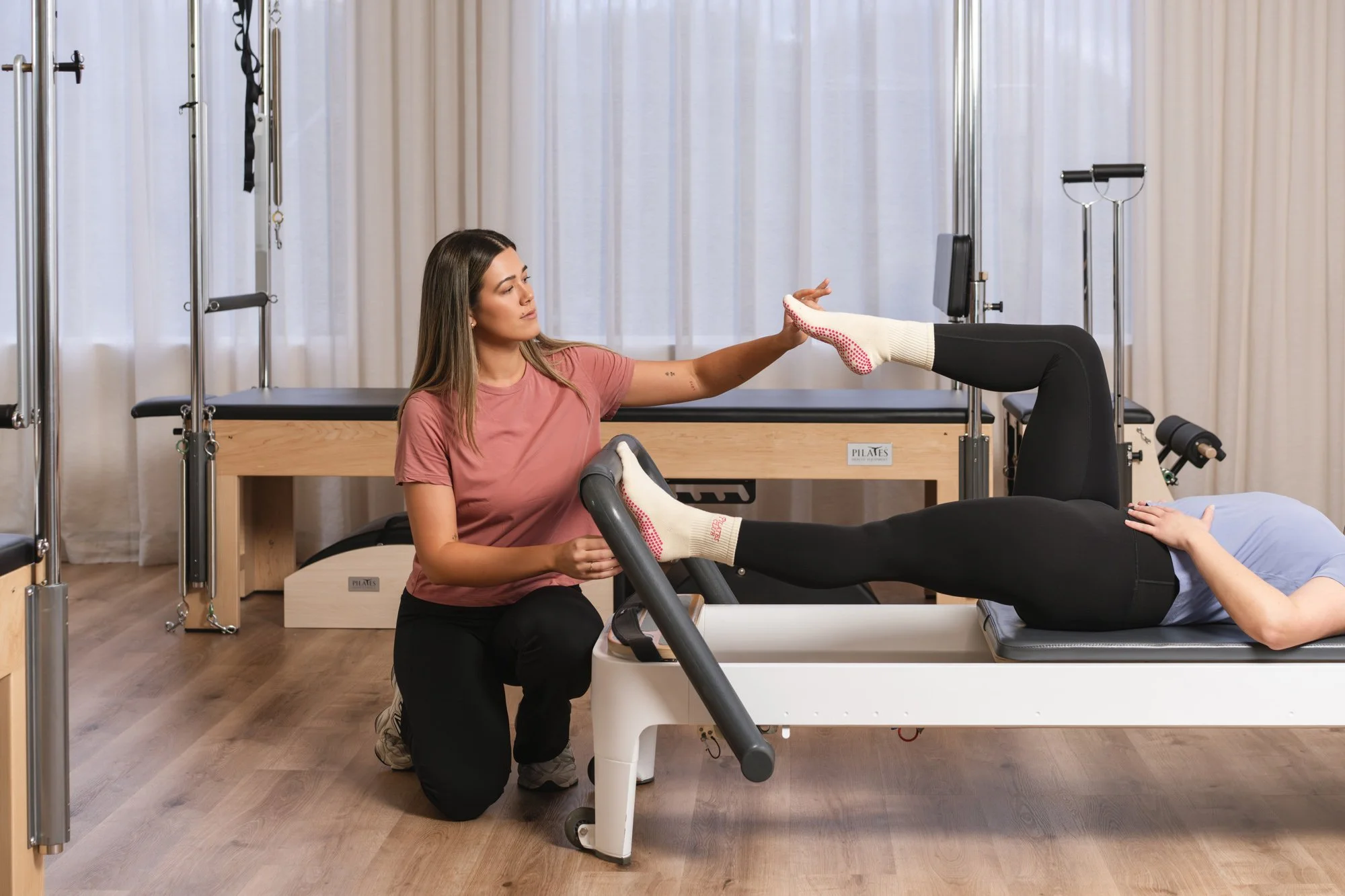 Clients moving through a Reformer class in the light-filled any.BODY studio