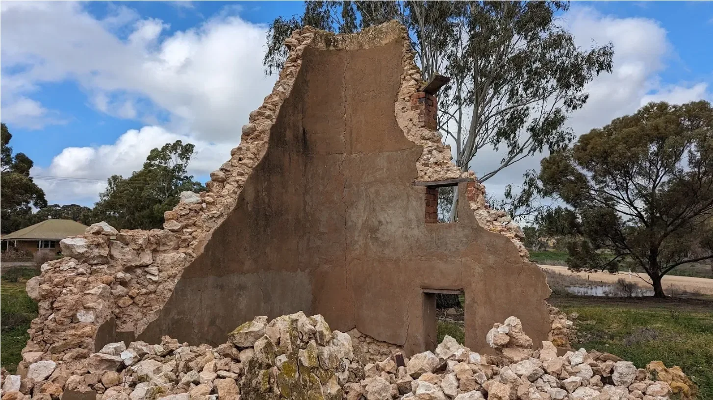 Partially collapsed masonry wall in a rural setting