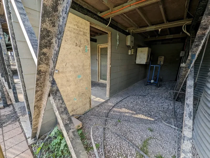 Flood-damaged under-house area with exposed framing