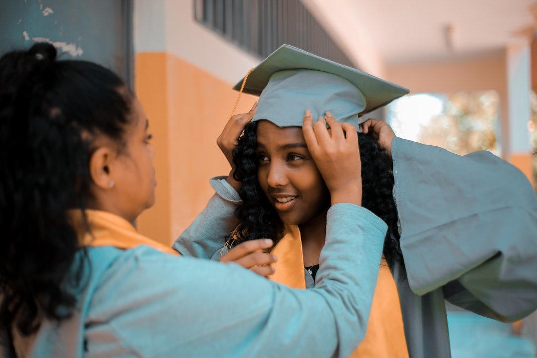 Mom adjusting her daughter's graduation cap, an emotional moment in the college transition journey