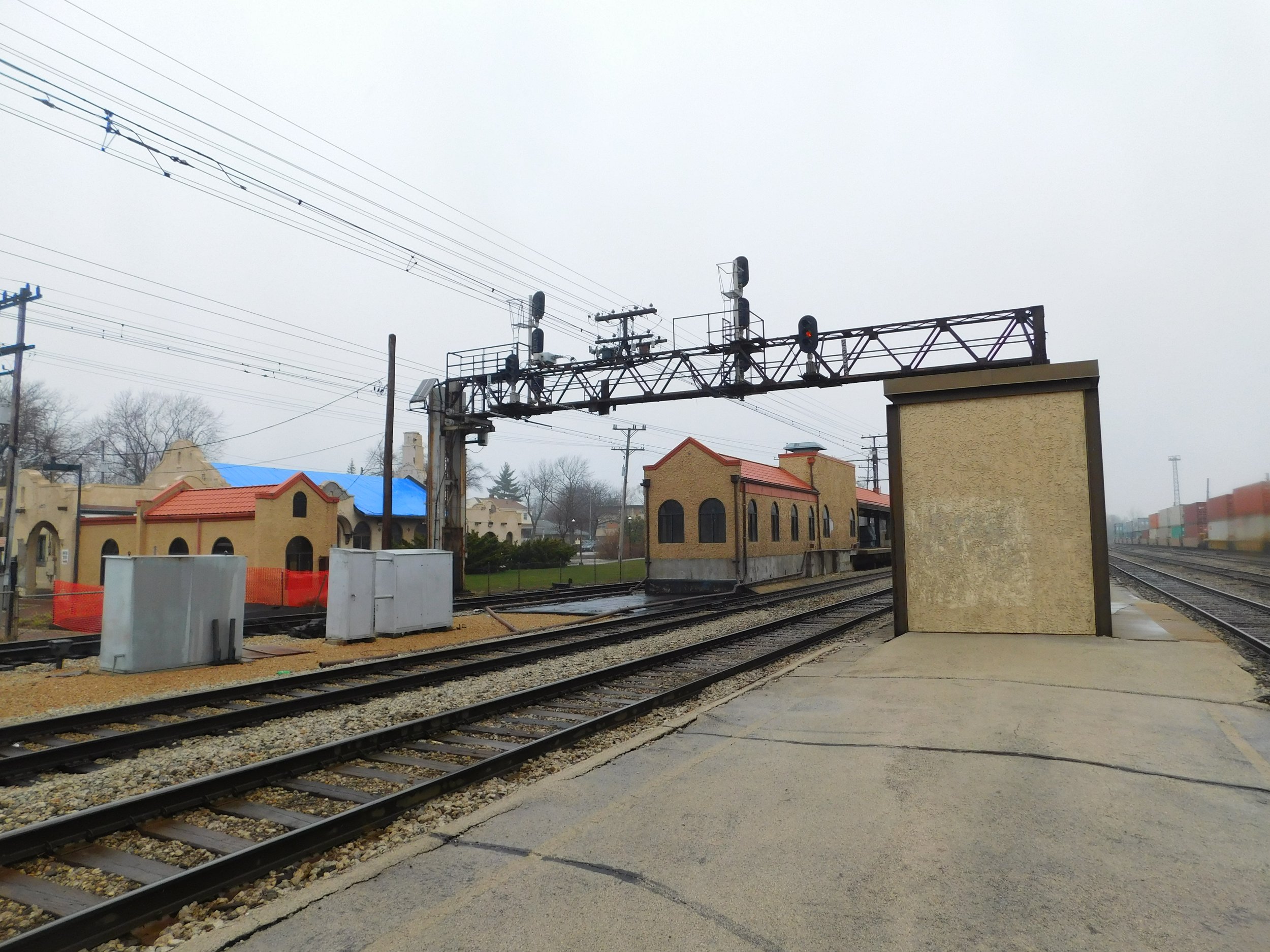 The Mission Revival depot at Homewood station, with arched windows and a tile roof beside the tracks