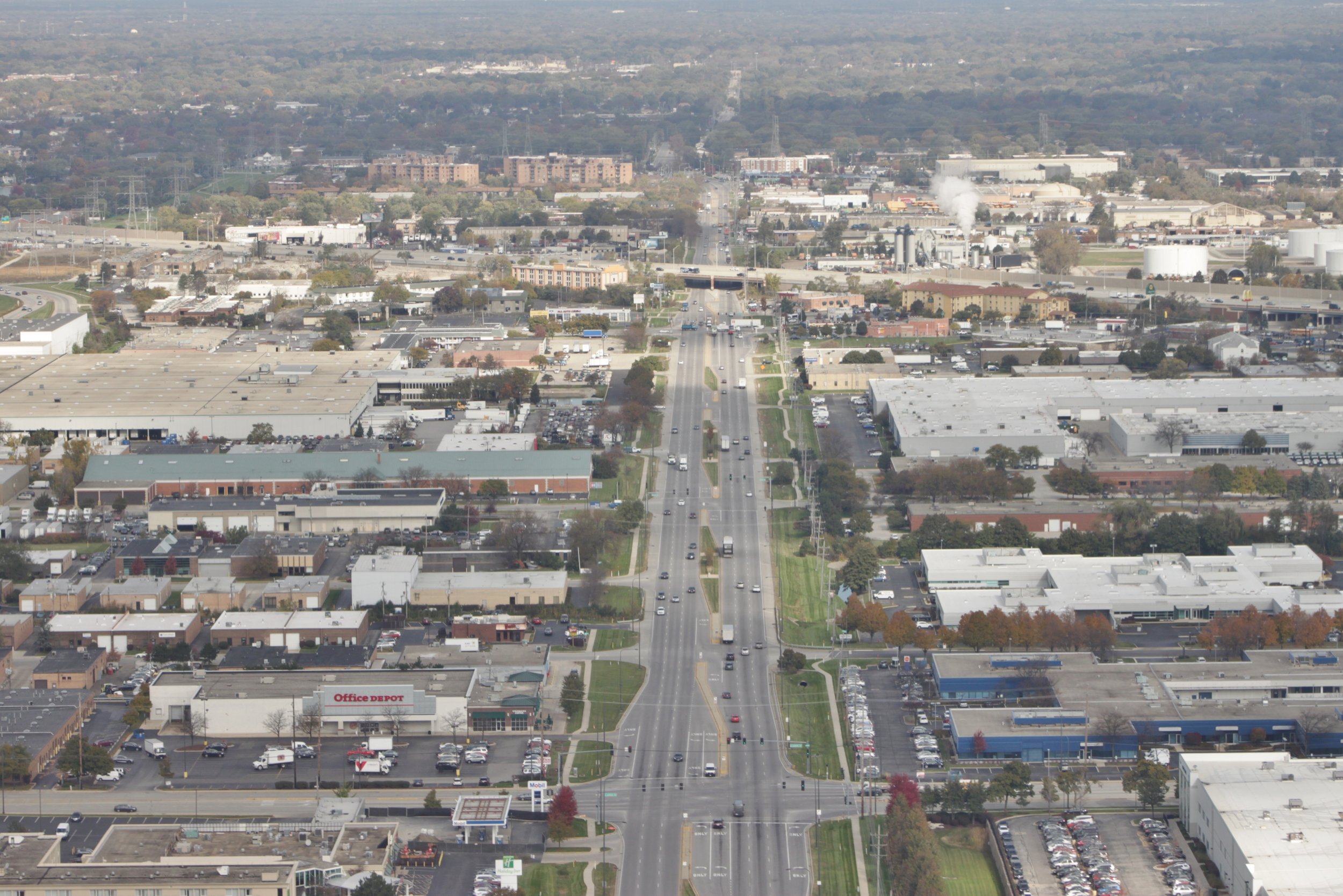Aerial view looking north up Busse Road in Elk Grove Village, with warehouses and low commercial buildings on both sides of the road