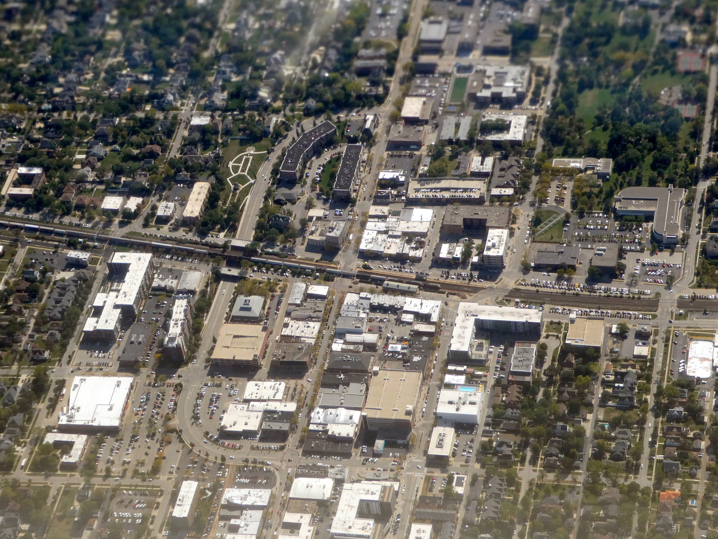 Aerial view of downtown Elmhurst, with the Metra tracks crossing the street grid and tree-lined blocks of houses at the edges