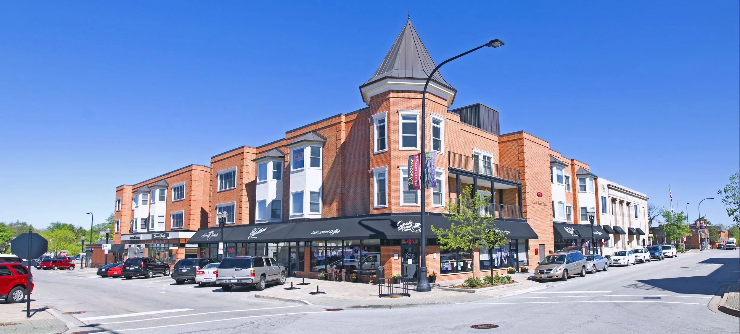 Brick shop buildings with a corner turret at Cook Street and East Station Street in downtown Barrington