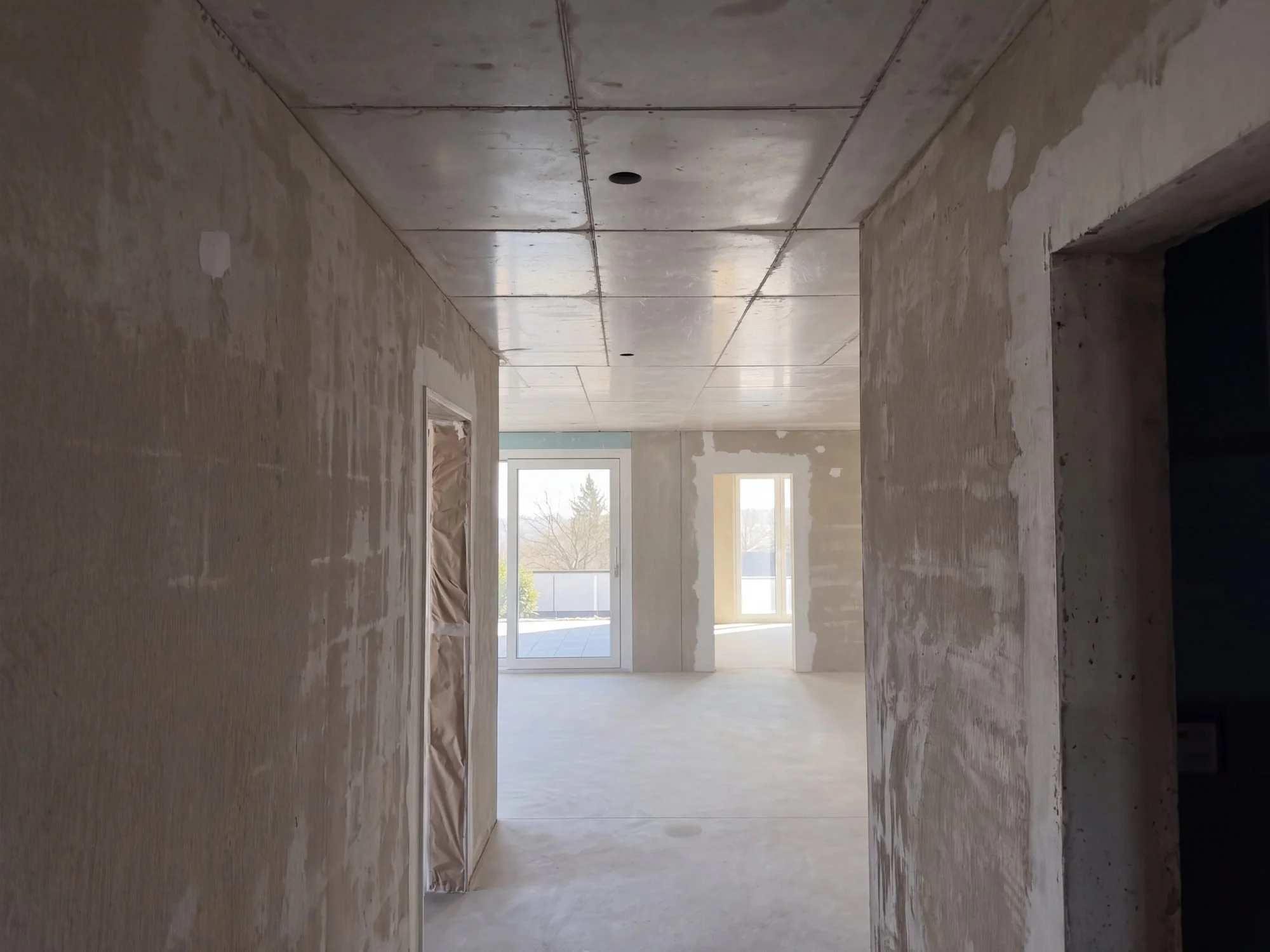 Blick durch das Entrée in den Wohnraum, Oktober 2026