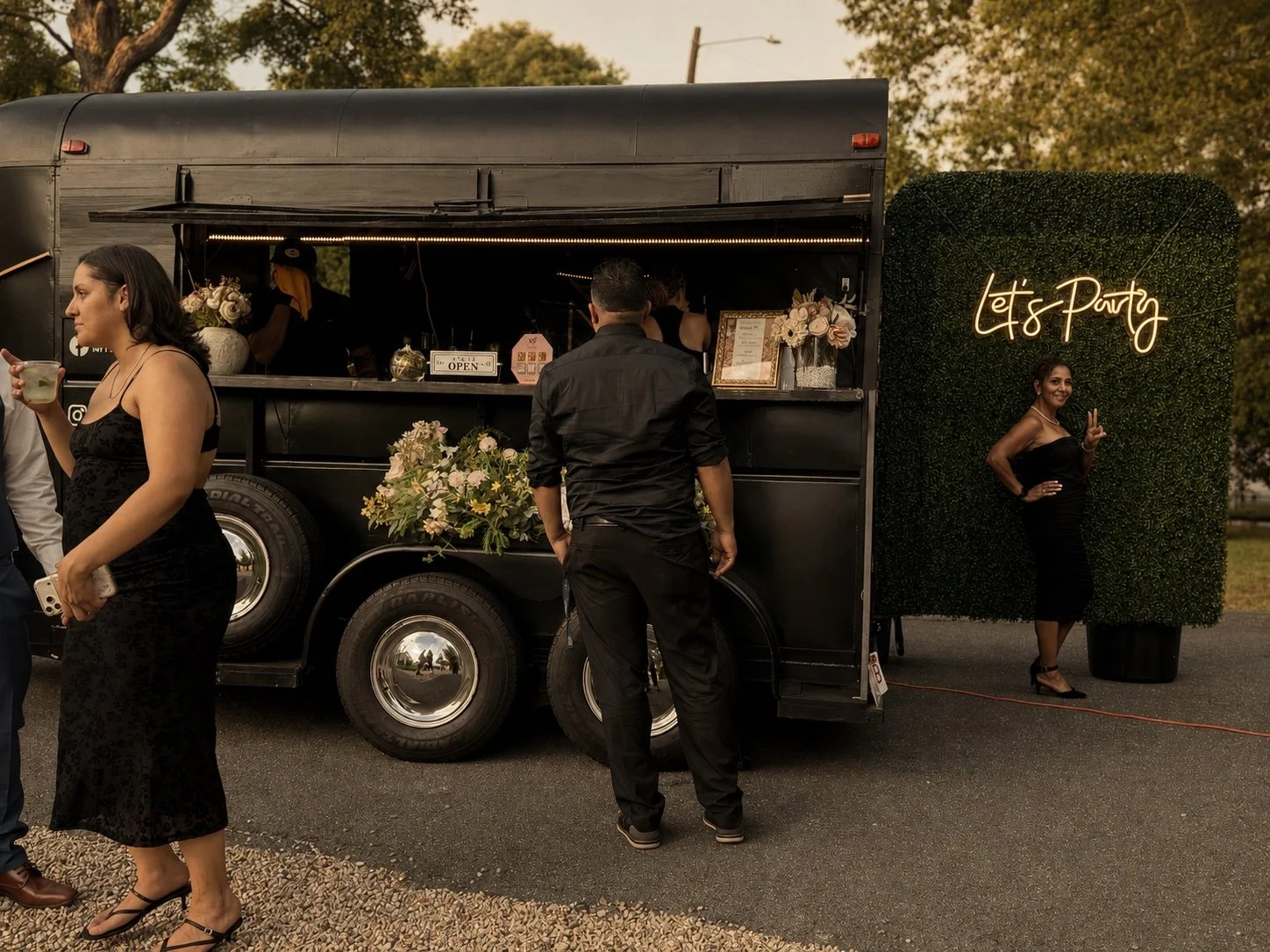 Guests gathering around the Mixhaulogy vintage trailer at an evening celebration