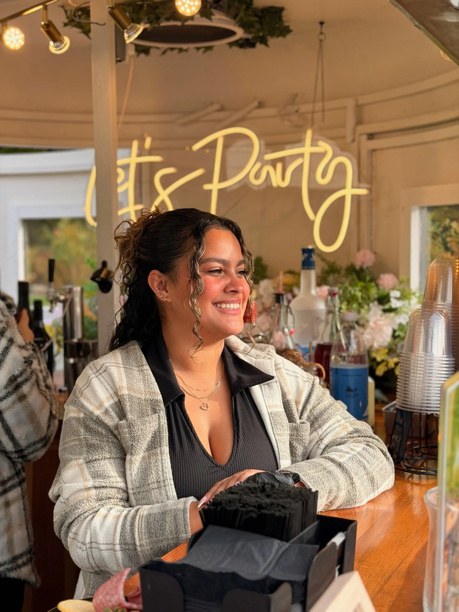 A smiling Mixhaulogy bartender welcoming guests inside the mobile bar