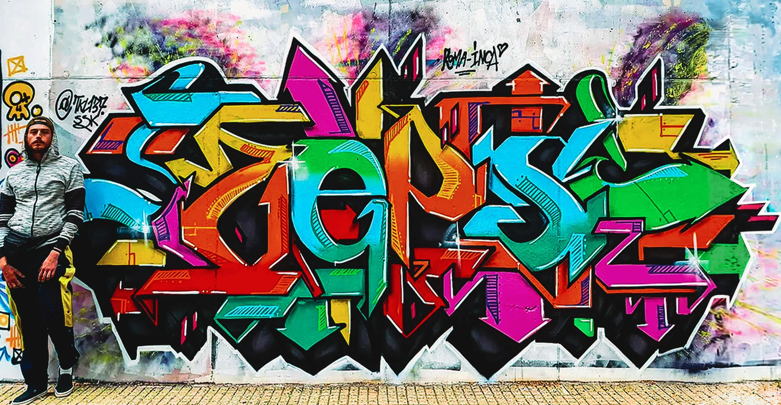 Artist standing with finished wall — orange/teal symphony and depth.