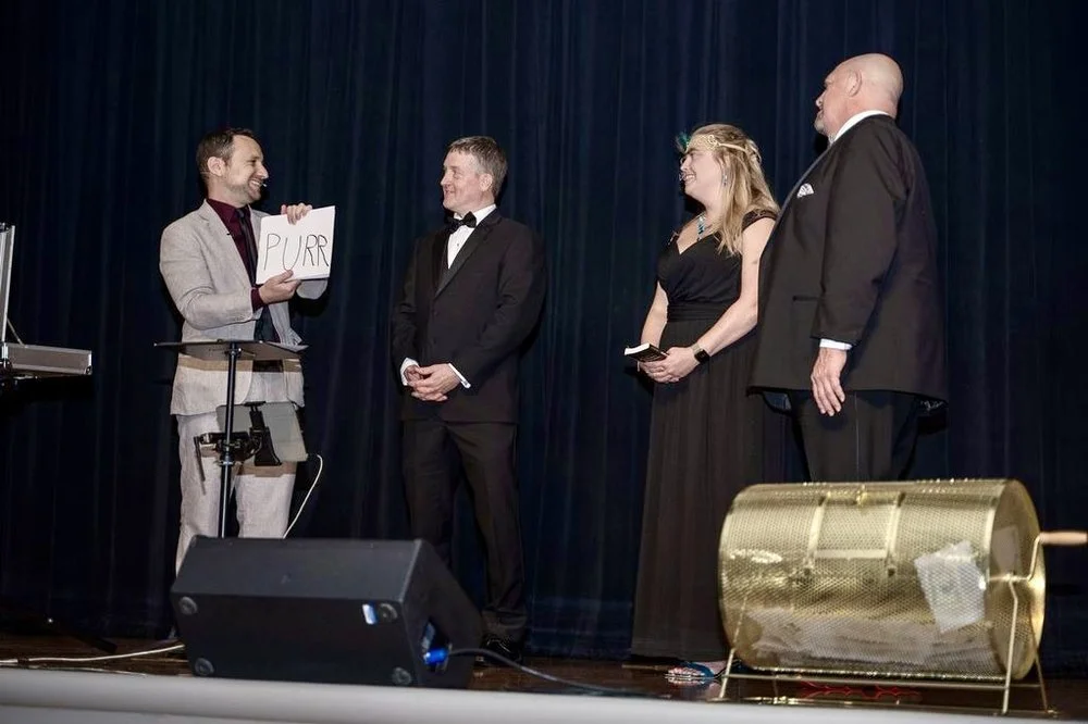 Ari Novick performing stand-up magic on stage for a corporate event audience
