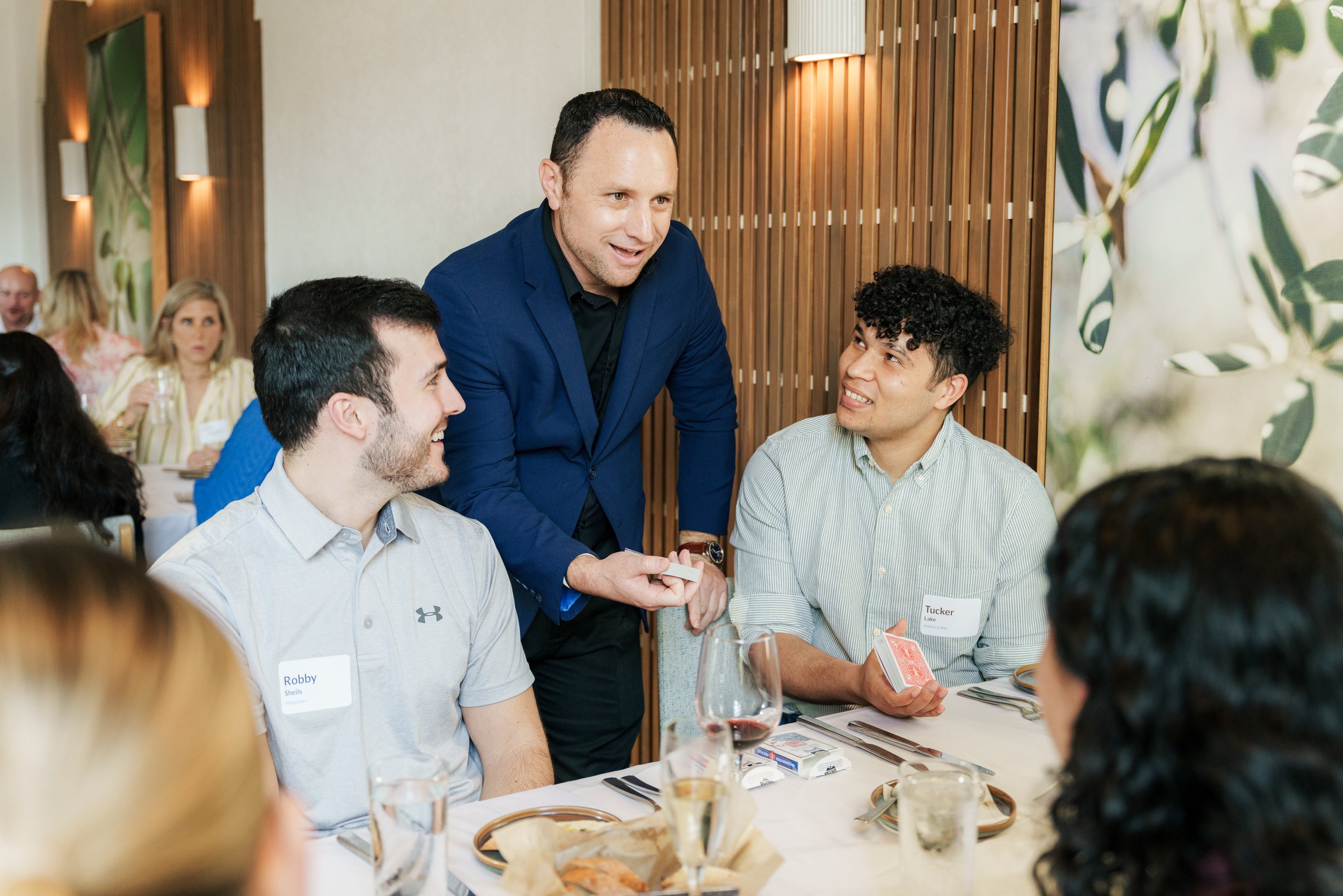 Ari Novick performing close-up magic for guests during a corporate cocktail hour in Atlanta.