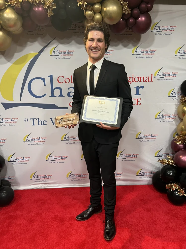 Daru Pretorius holding Golden Thread Consulting's Newcomer Entrepreneur award and certificate at the 2026 Cold Lake Business of the Year Awards