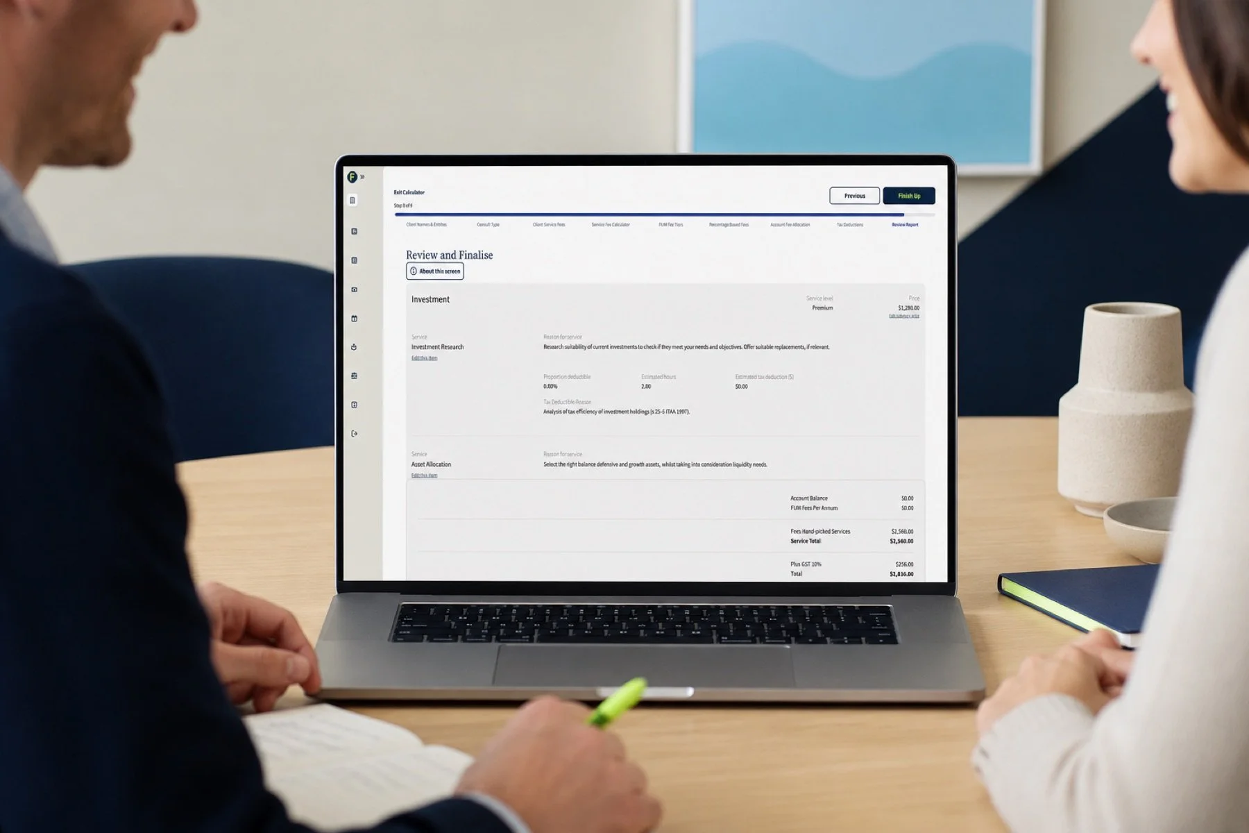 An adviser and client reviewing a fee report together in the Finwise Calculator