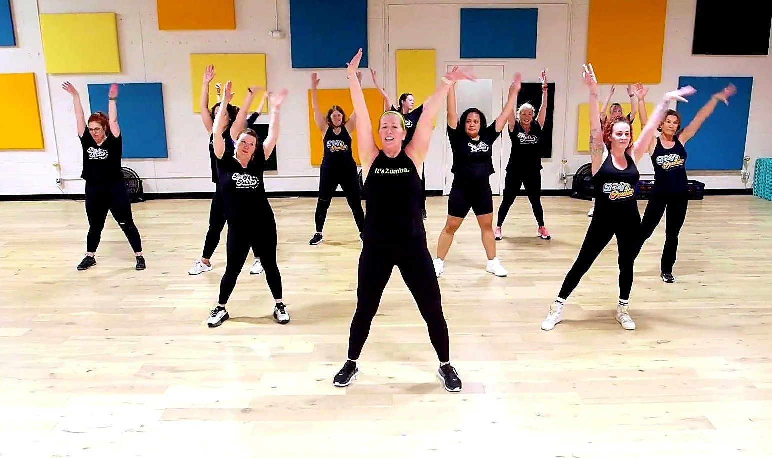 The BPDF crew together in the studio, raising their arms and sharing a joyful moment