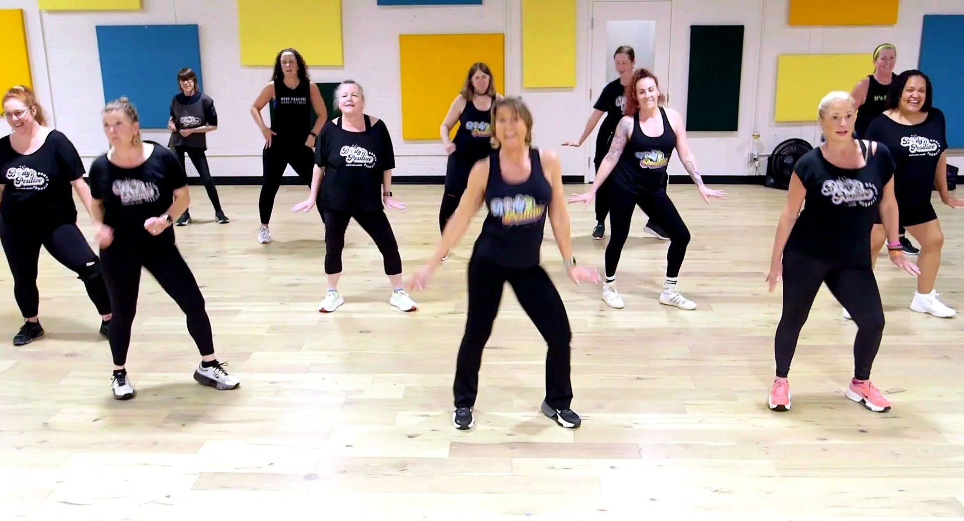 A smiling BPDF instructor leading class in dynamic motion