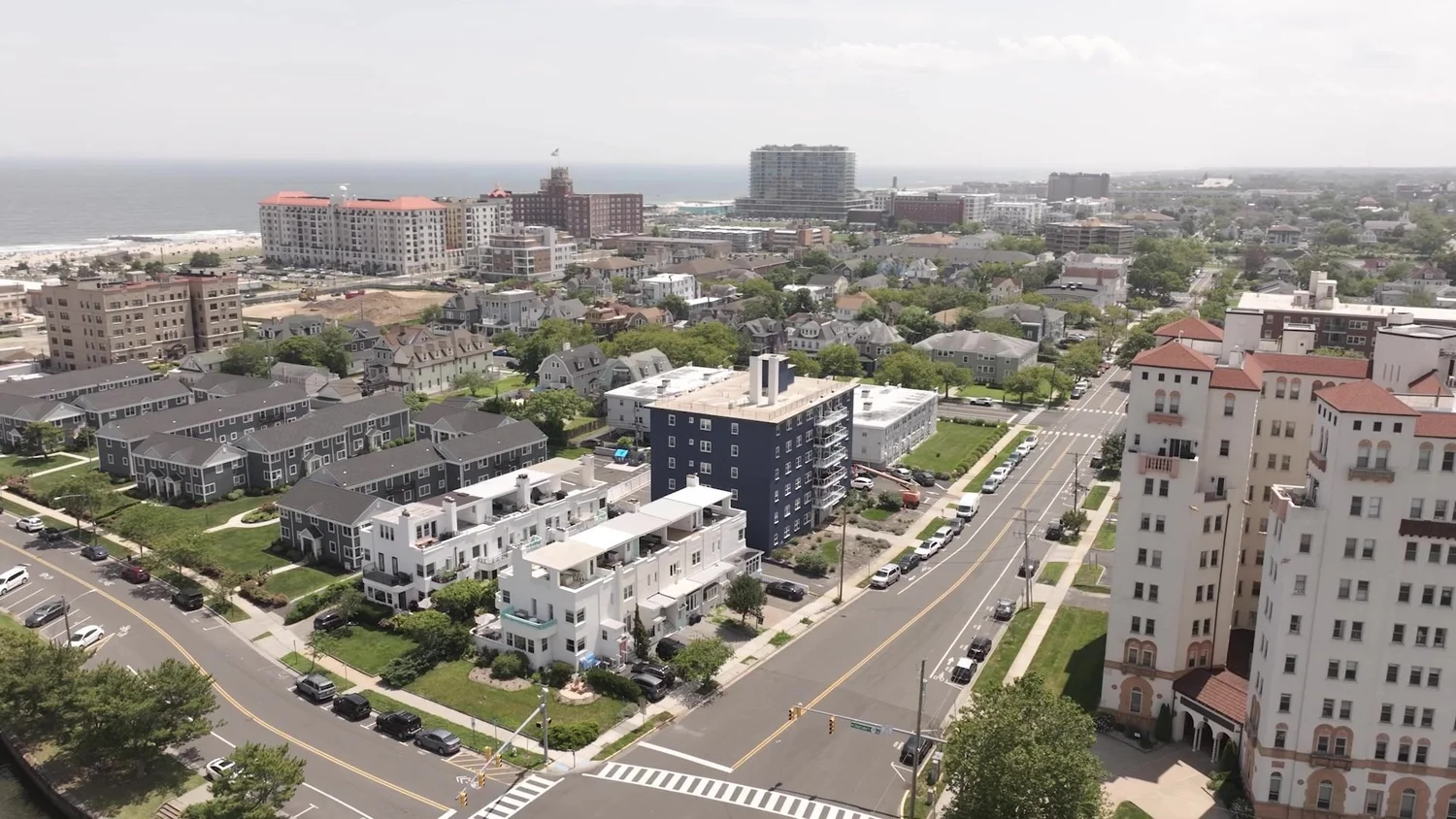 Drone aerial over a Jersey Shore town street grid, looking toward the ocean
