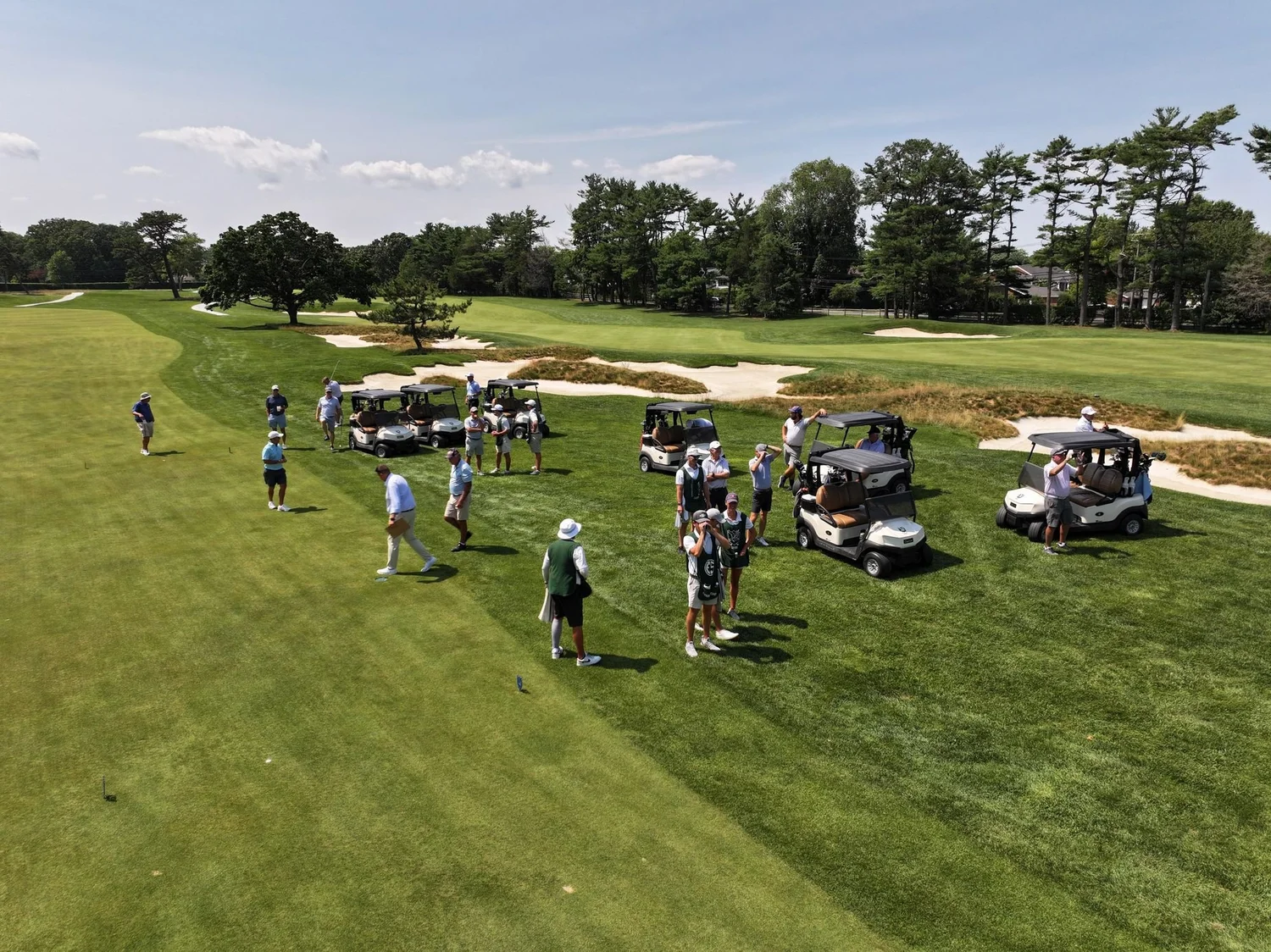 Golfers and carts gather on a fairway, a scene for a private club membership video