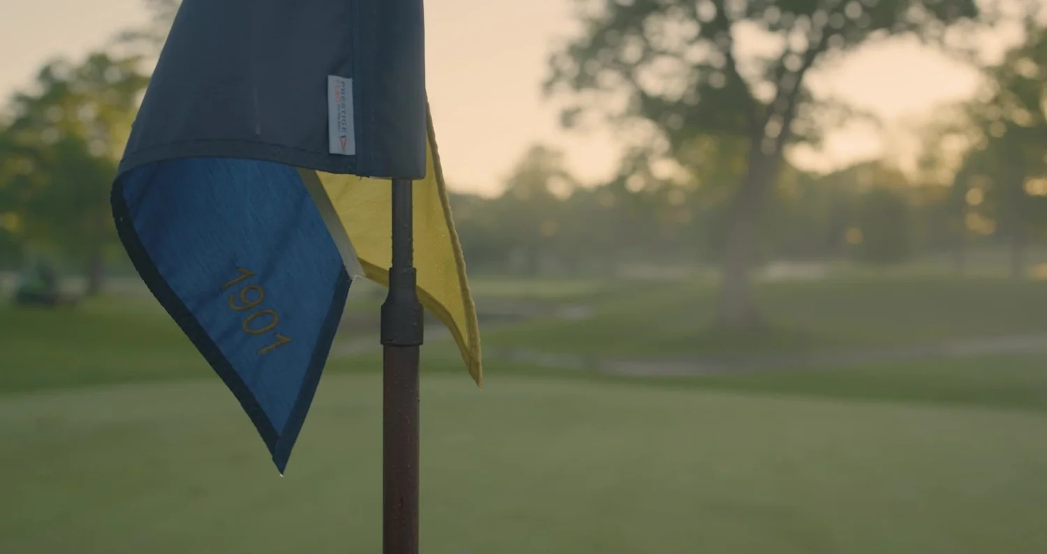 Pin flag on a golf green at dawn in soft early morning light