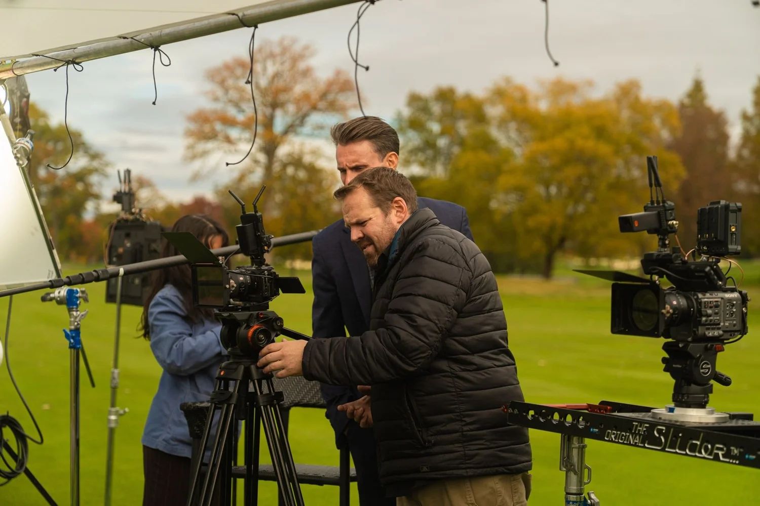 Private club video production crew around a cinema camera rig on a golf course in autumn
