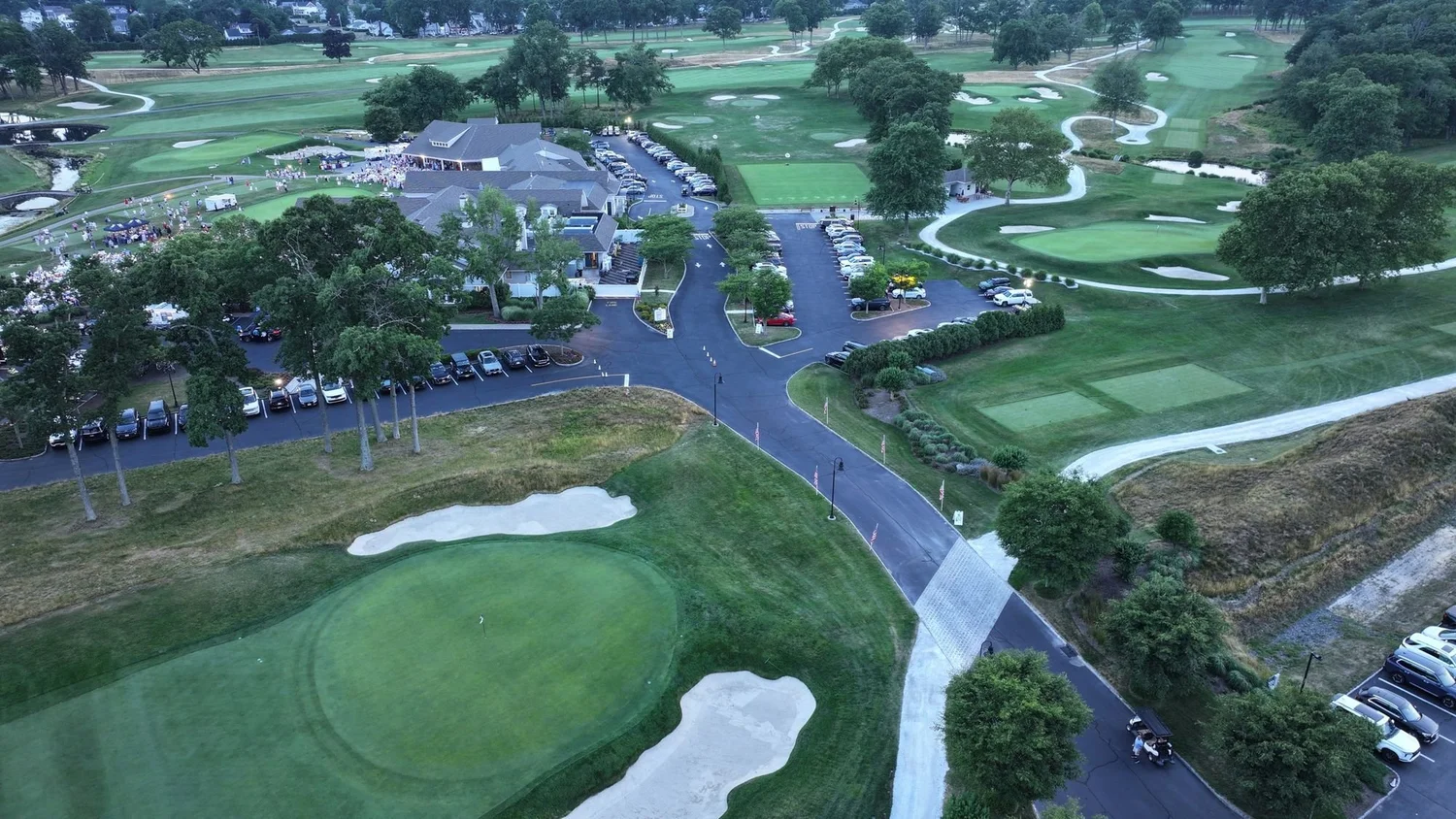 Drone aerial of a green, bunkers and cart paths near the clubhouse