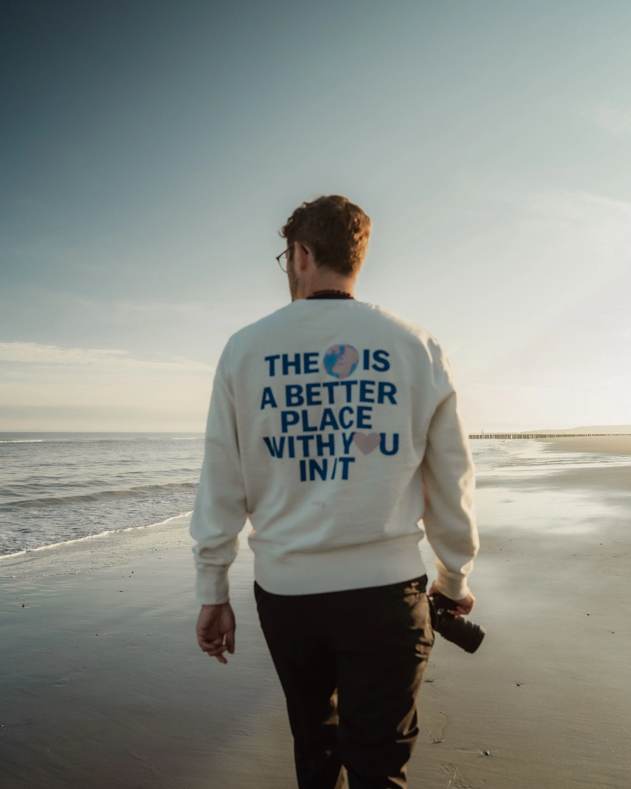 Florian Kirschbaum geht mit seiner Kamera am Strand entlang