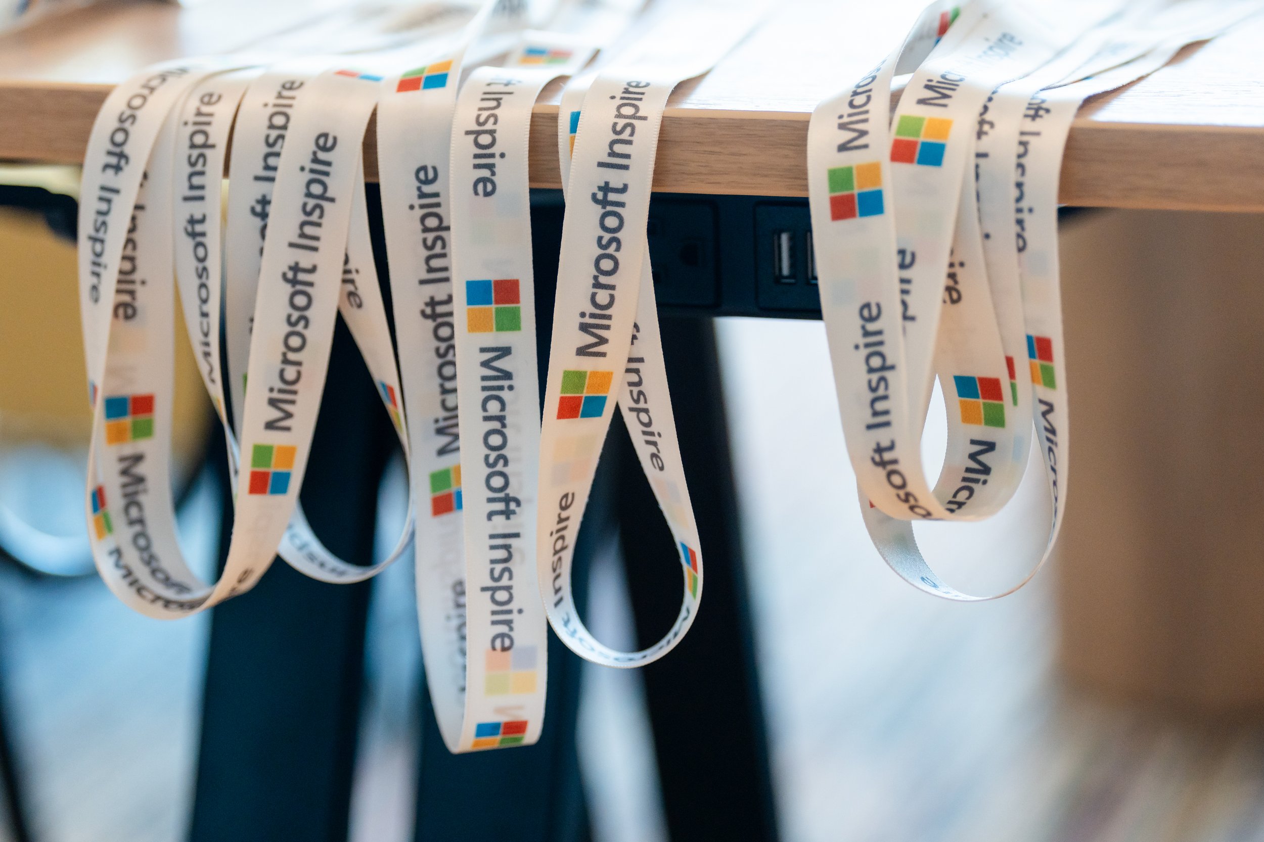 Close-up of hanging conference lanyards featuring event sponsors and colorful designs.