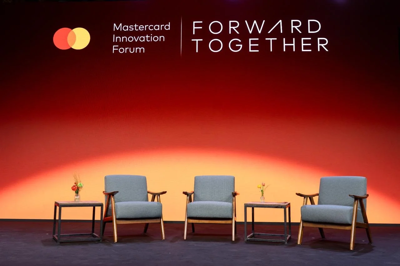 Mastercard Innovation Forum stage with Forward Together backdrop and three chairs