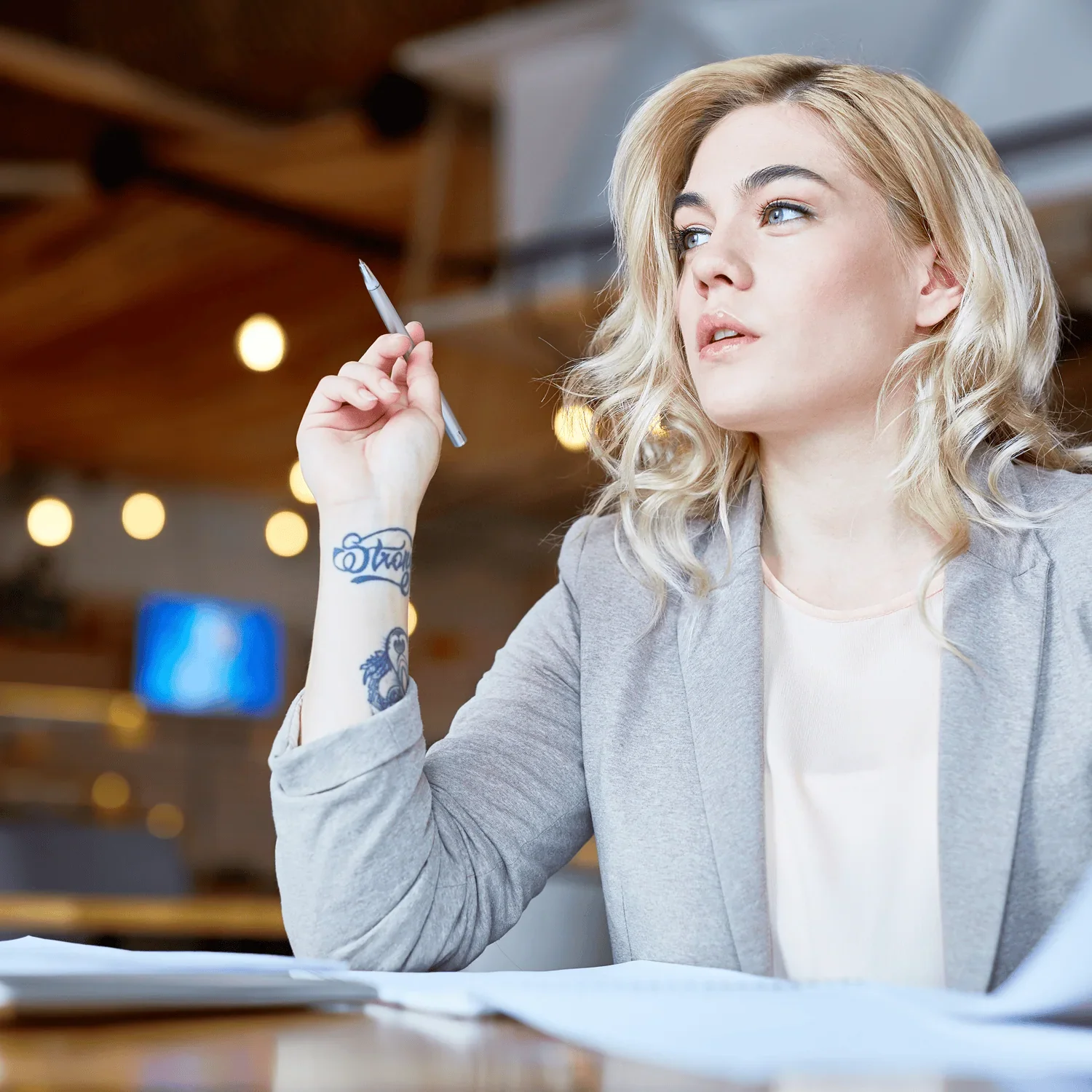 woman holding pen reviewing documents related to membership pricing