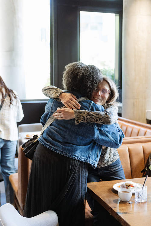 Henley team members sharing a hug