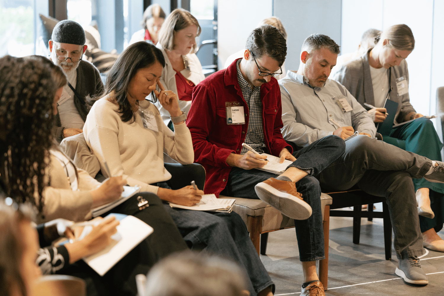 Leaders seated together in a group, taking notes during a session