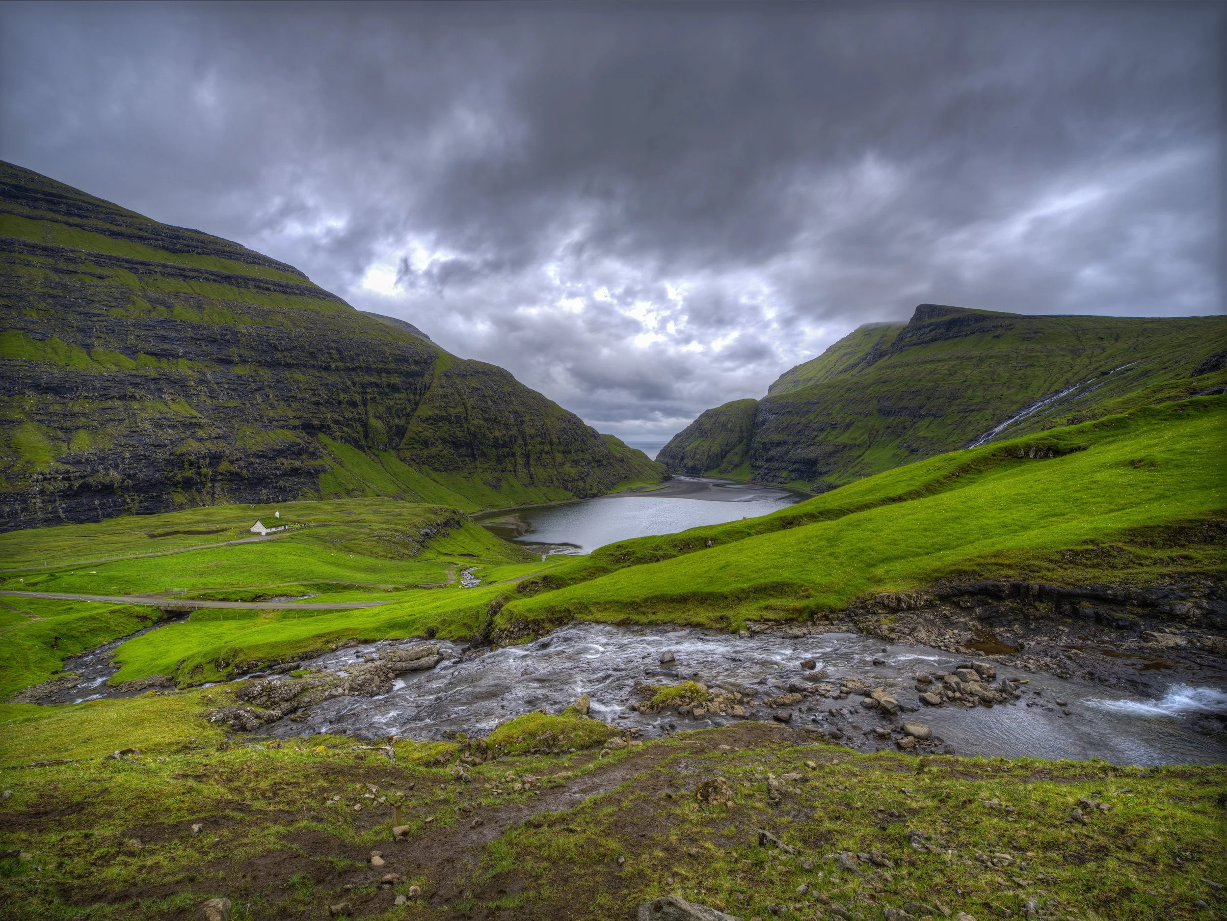 Green hills overlooking a lake beneath cloudy skies