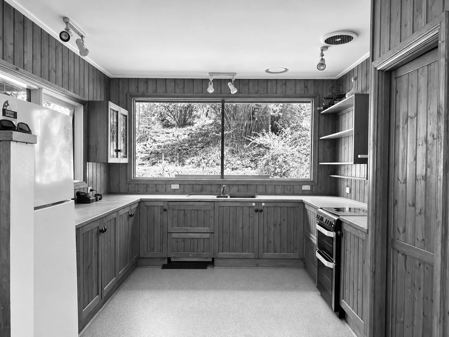 Before: the 1980s timber kitchen with a window to the bush