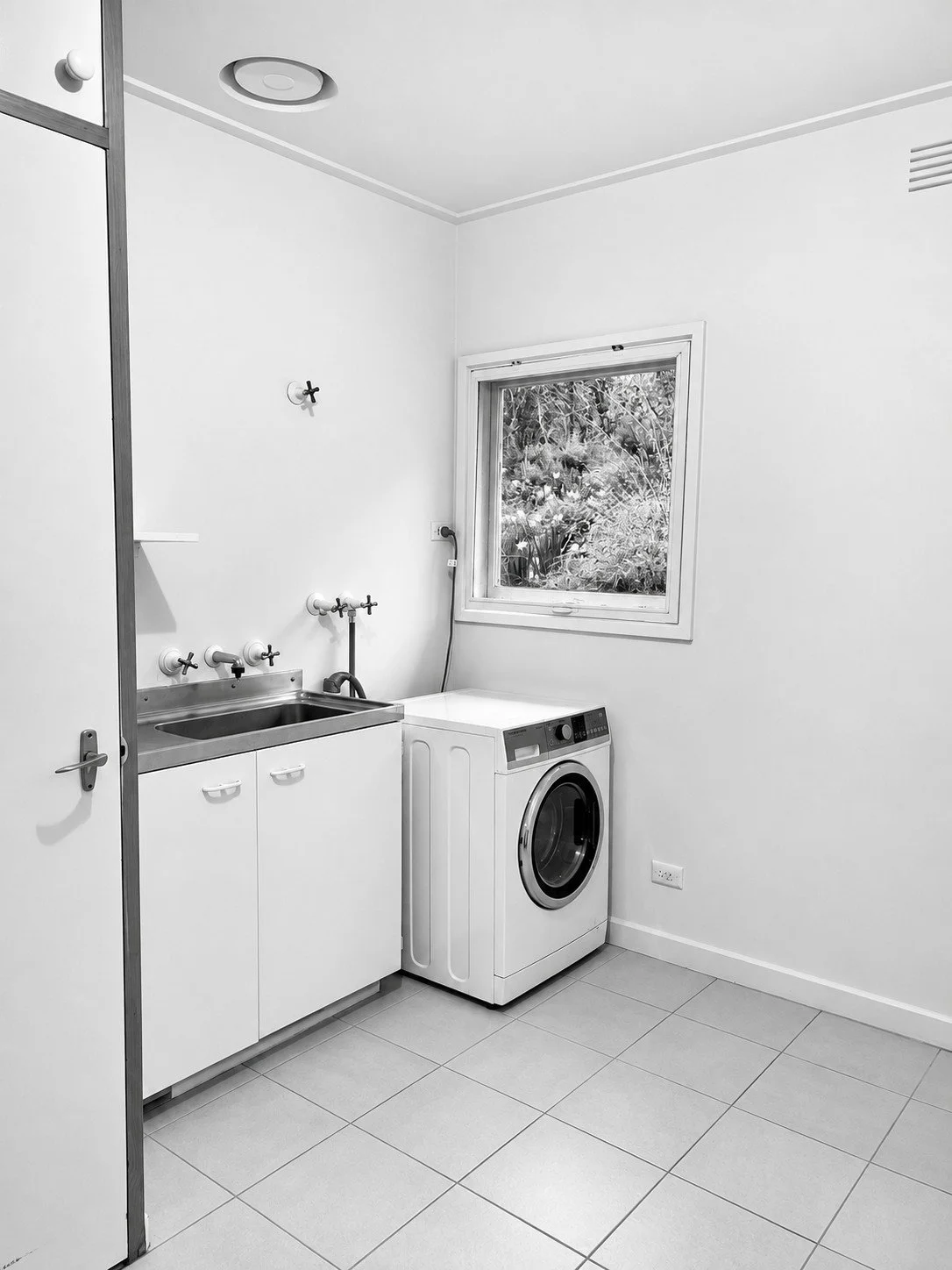 Before: a plain laundry with a single cabinet and washing machine