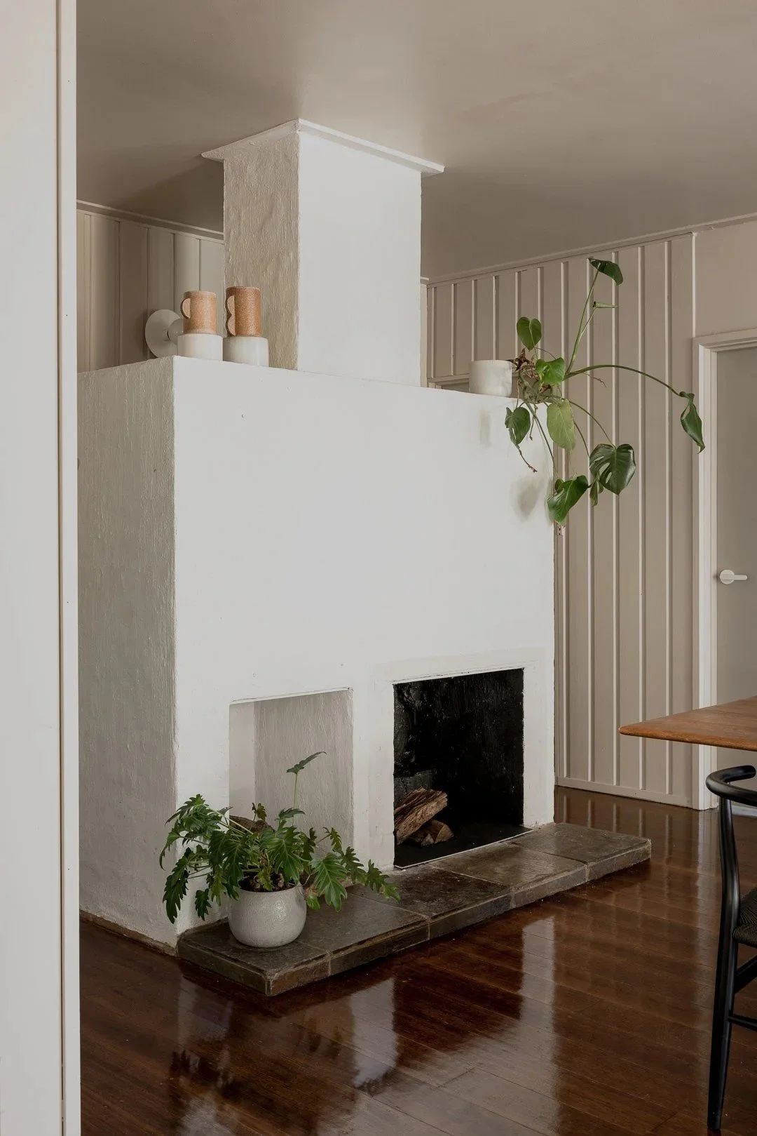 The white free-standing fireplace on a timber floor