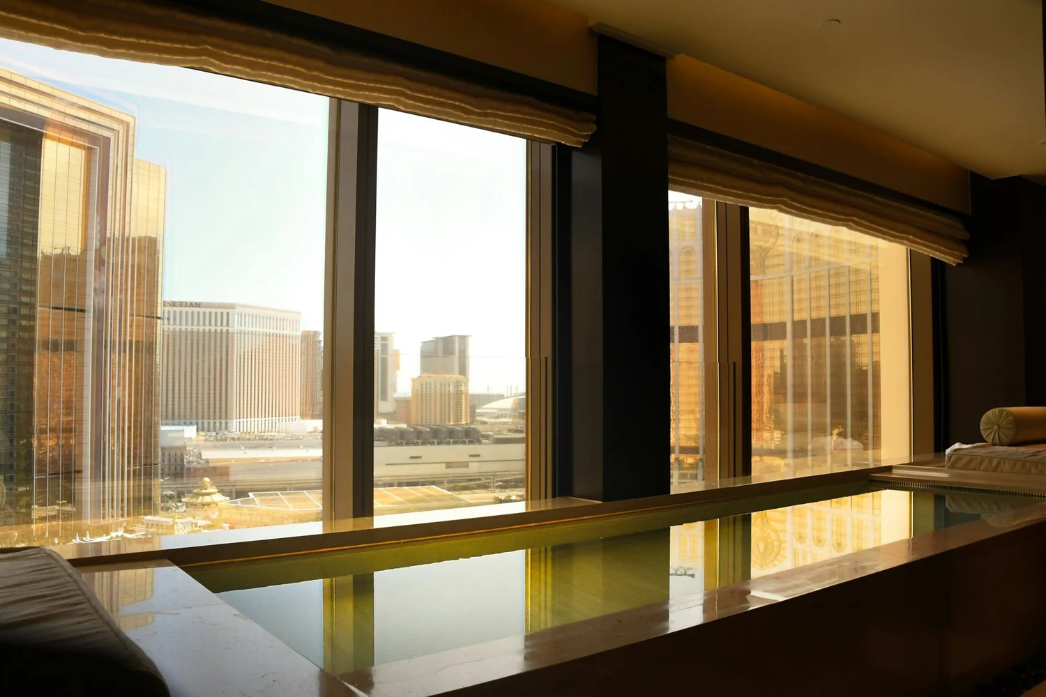 A hotel suite with floor-to-ceiling windows over the city