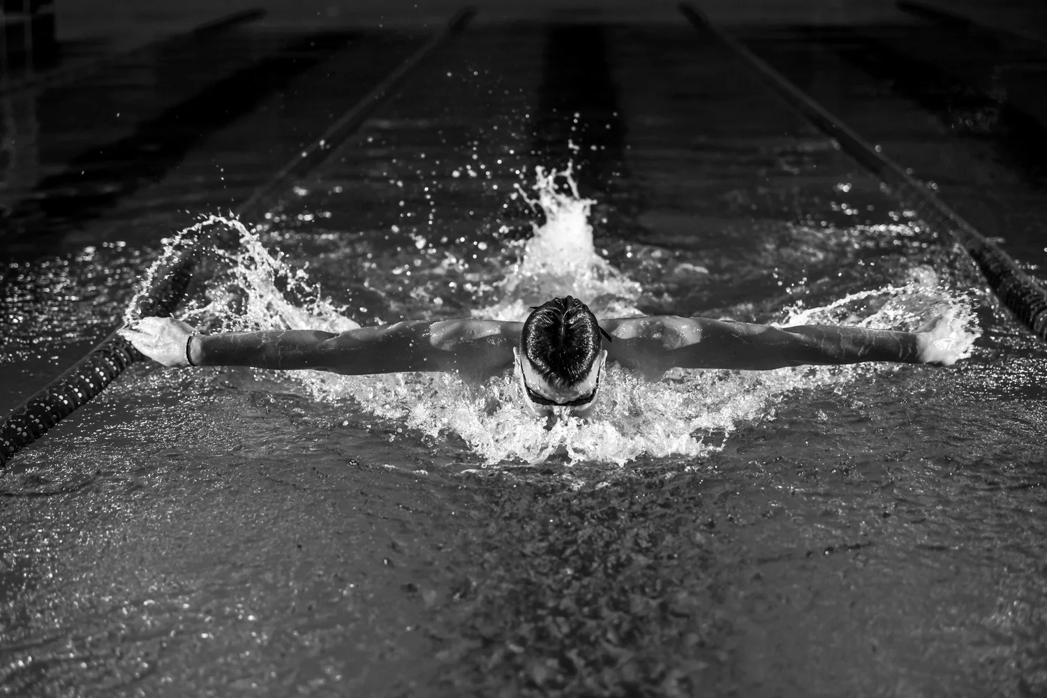A swimmer mid butterfly stroke