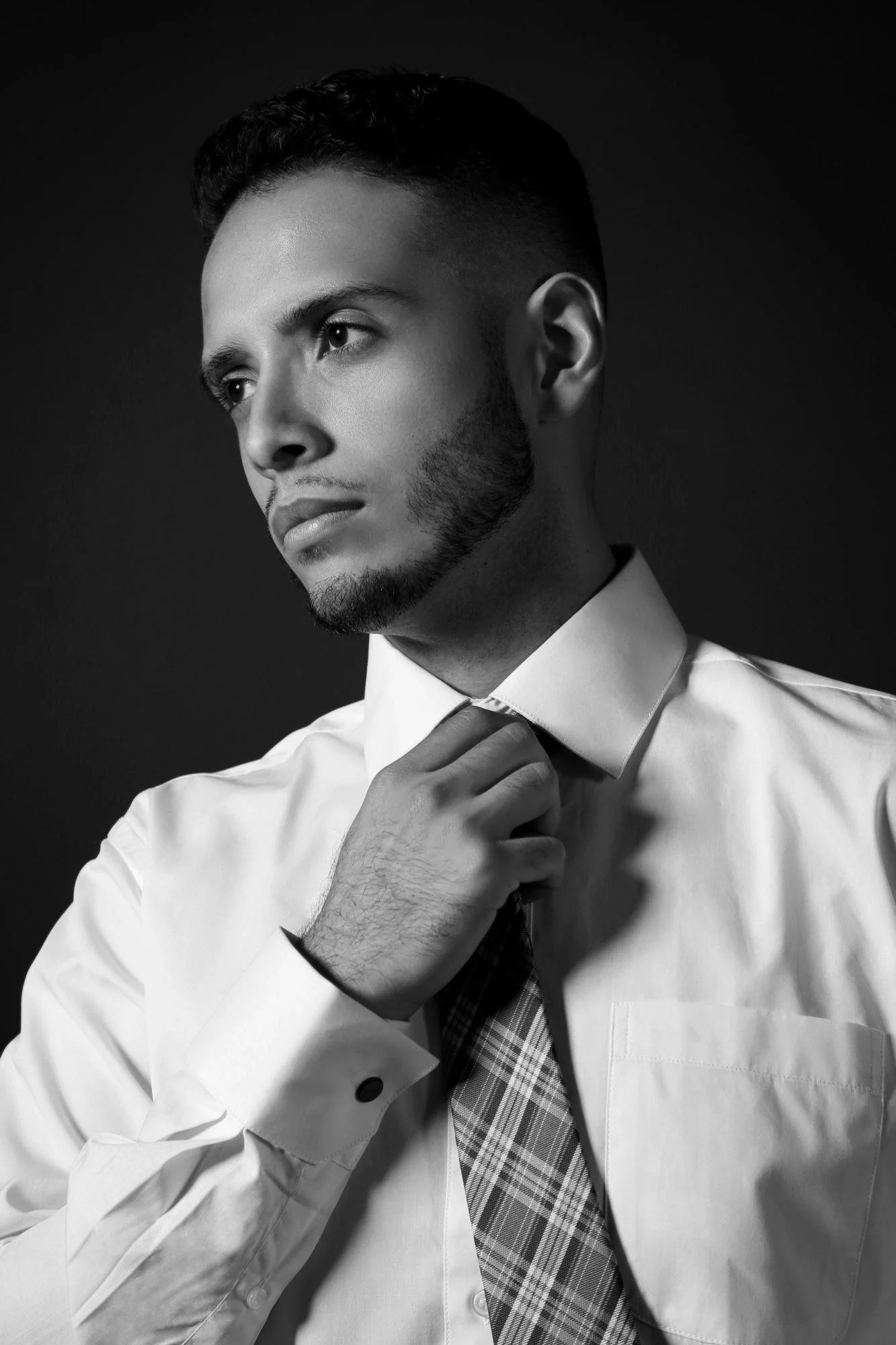 A man in a dress shirt loosening his tie