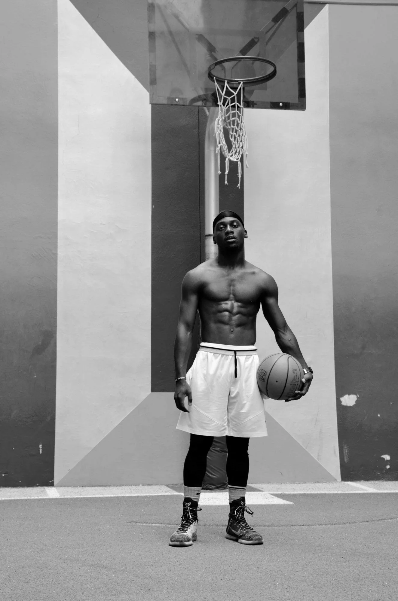 A shirtless basketball player on a painted court