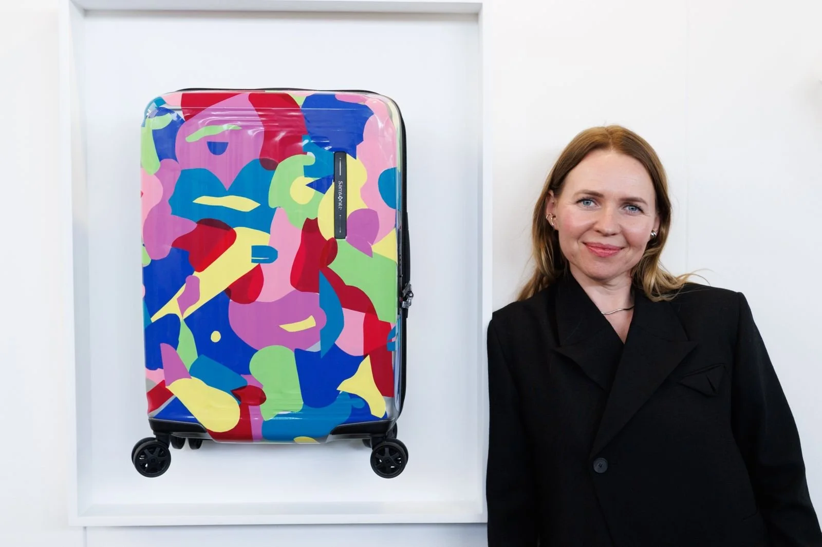 Anastasia Shi beside Home Within, her colorful Samsonite NUON suitcase intervention at BADA México 2026