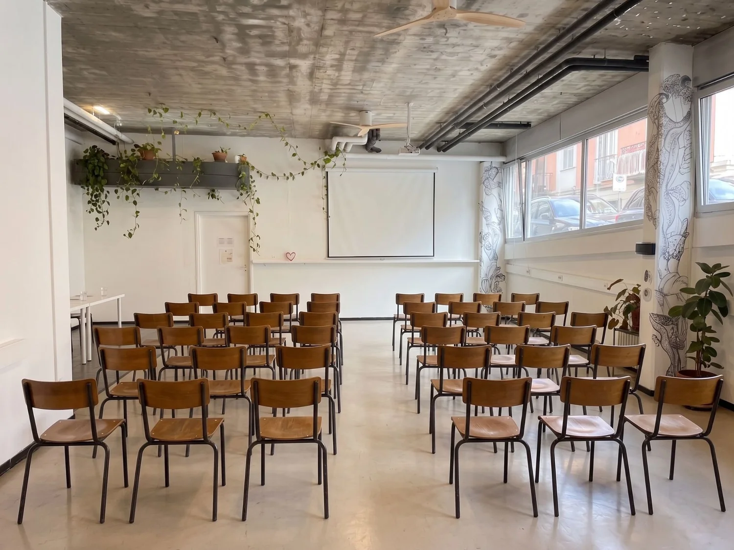Salle de séminaire à Genève en configuration plénière, écran déroulé et une cinquantaine de chaises