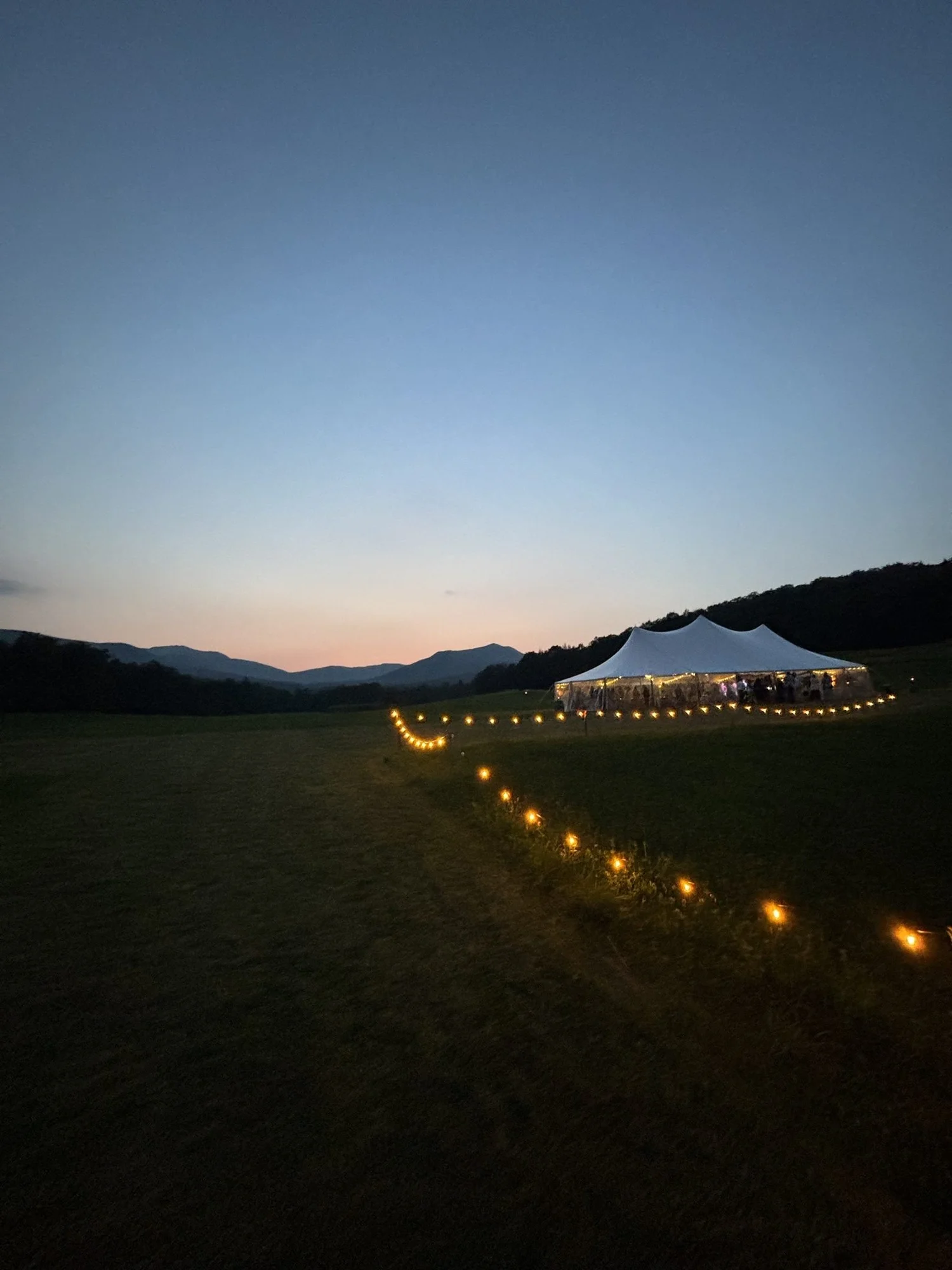 Sailcloth tent wedding at dusk in the Vermont mountains