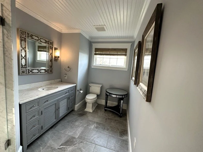 Remodeled bathroom with vanity, tiled floor, beadboard ceiling and custom trim